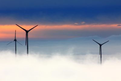 A wind farm rising out of the mist.