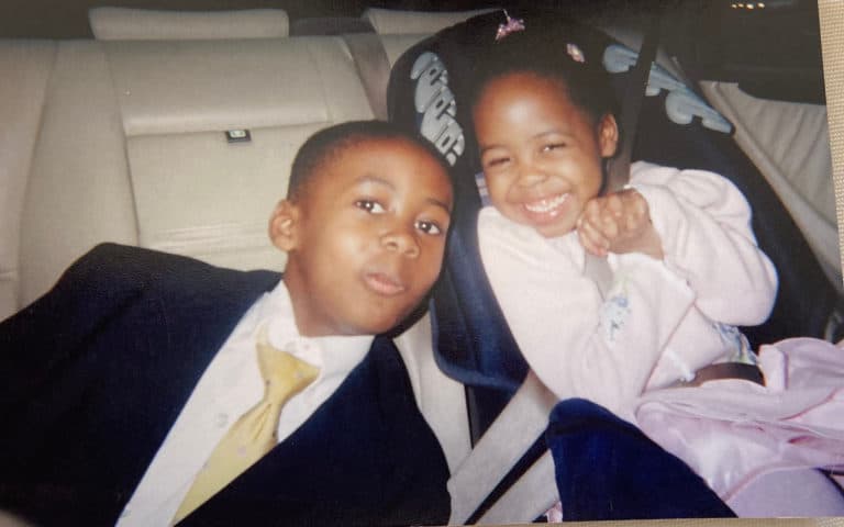 Emma McMillian, young, with her brother in a car